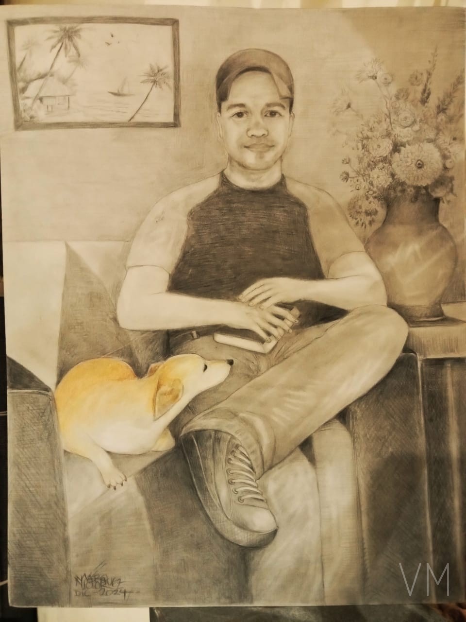 Retrato de un joven sentado en sofá con cuadro tropical y su perrito color miel.